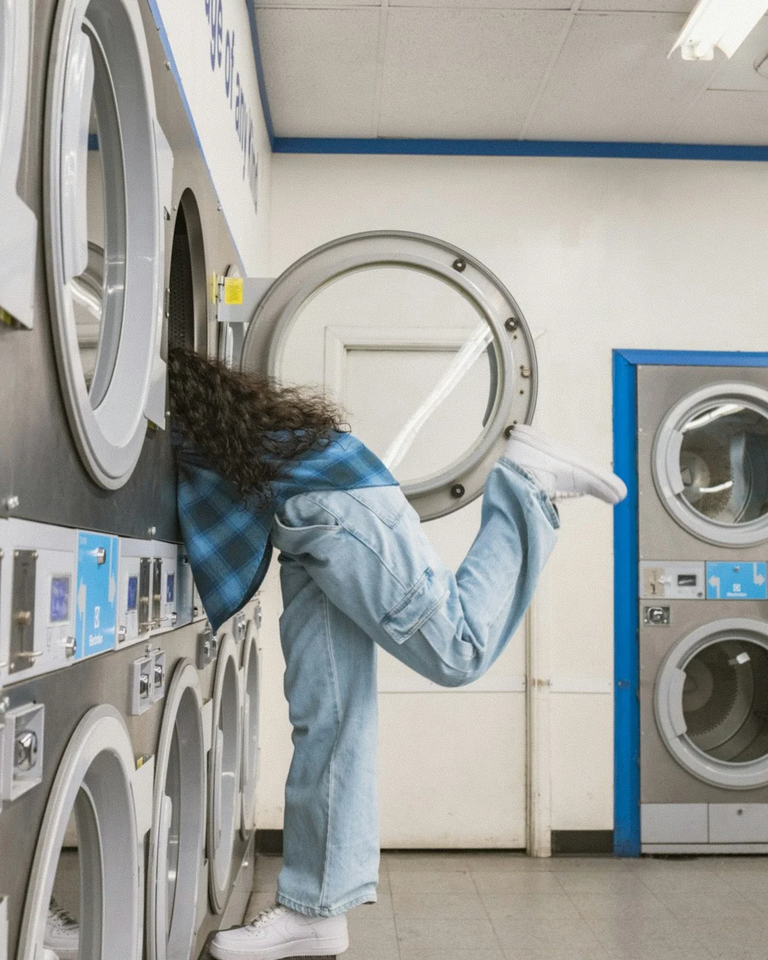 A hotel housekeeper neatly stacks fresh towels in a luxurious room setting.